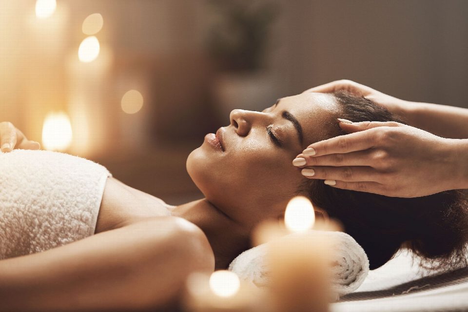 Cliente a receber uma massagem facial relaxante, à luz de velas